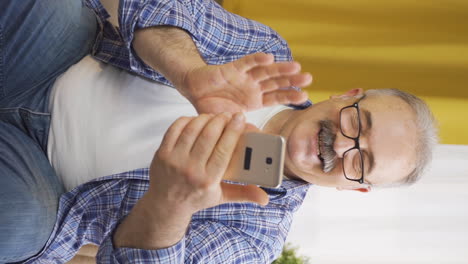 Vertical-video-of-Old-man-making-a-video-call-on-the-phone.